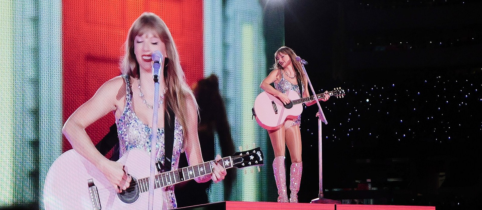 Taylor Swift playing a pink acoustic guitar on a pink stage during the Eras Tour Lover set