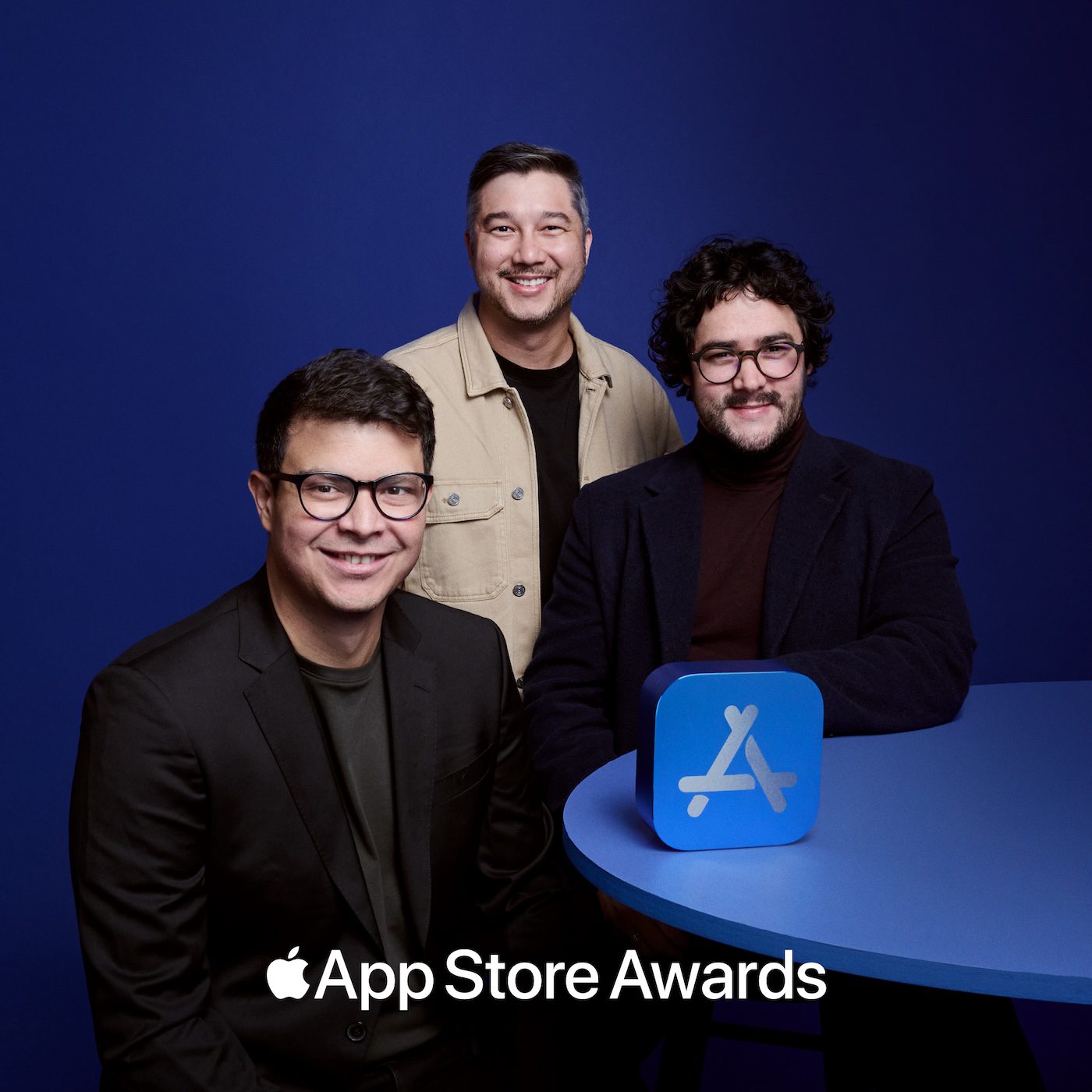 The Moises team posing against a blue backdrop with an Apple App Store Awards icon on a table, highlighting the recognition.